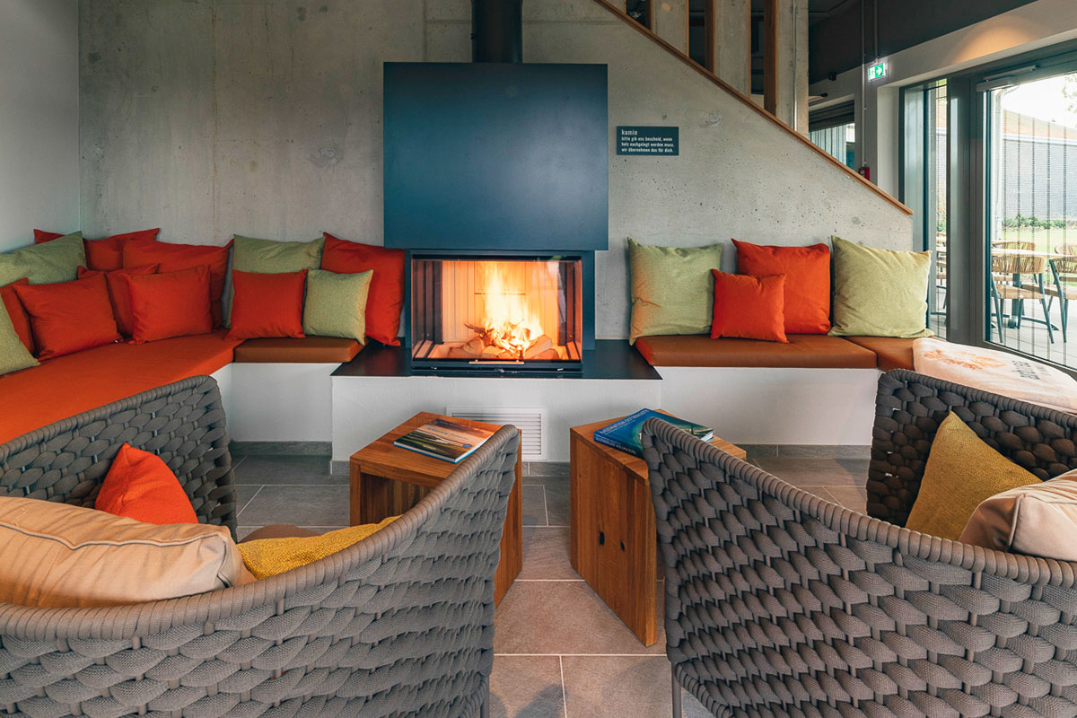 Kuscheliger Innenbereich mit Kamin und Sitzgelegenheiten im arborea Marina Resort Neustadt.