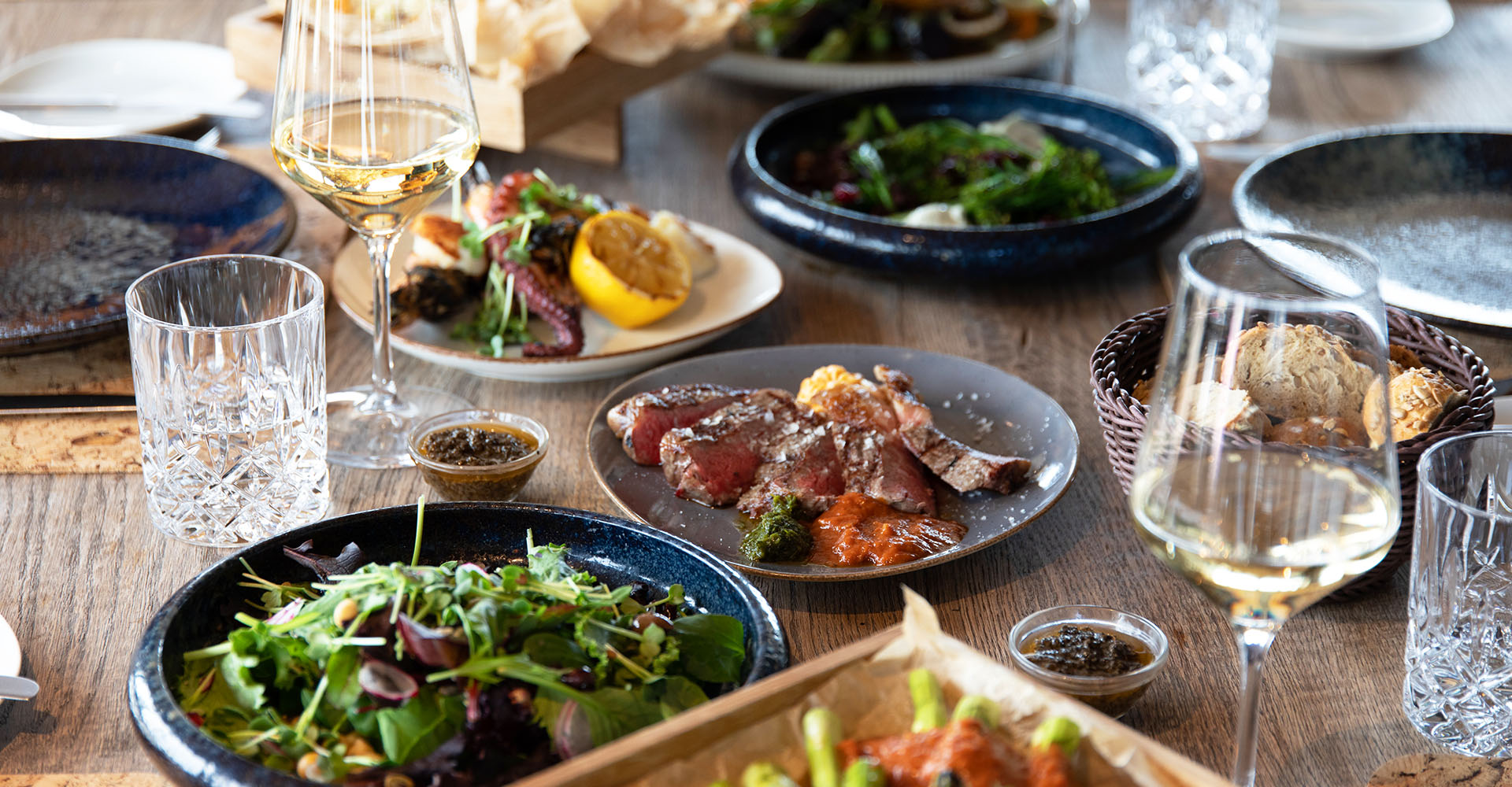 Geschmackvolle EInrichtung leckerer Fleisch und Meeresfrüchte Gerichte und Getränke mit Salaten in der Kutter Kitchen des arborea Marina Resort Neustadt.