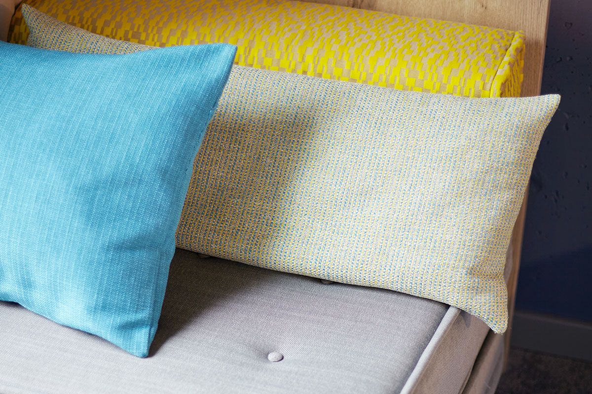 Nahaufnahme der kuscheligen Kissen auf einer Sitzgelegenheit im Viererzimmer Auszeit im arborea Marina Resort Neustadt.