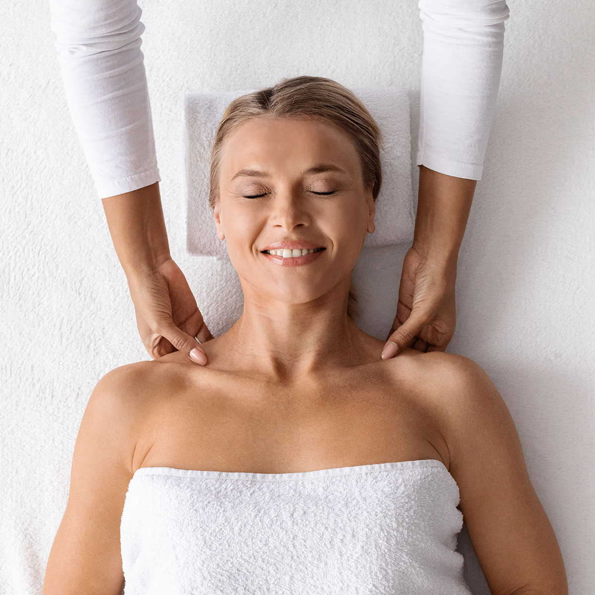 Eine Frau entspannt sich bei einer Ganzkörper-Pflegepackung auf einer Softpackliege im SPARADISE des arborea Marina Resort Neustadt.